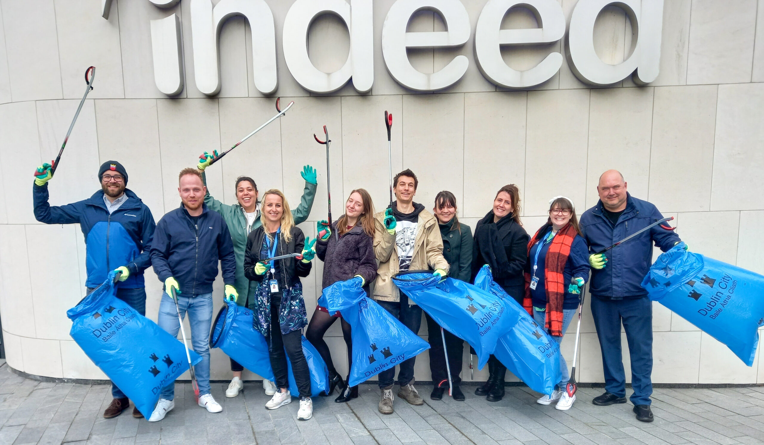 group of indeed employees outside the dublin office with trash bags collecting garbage
